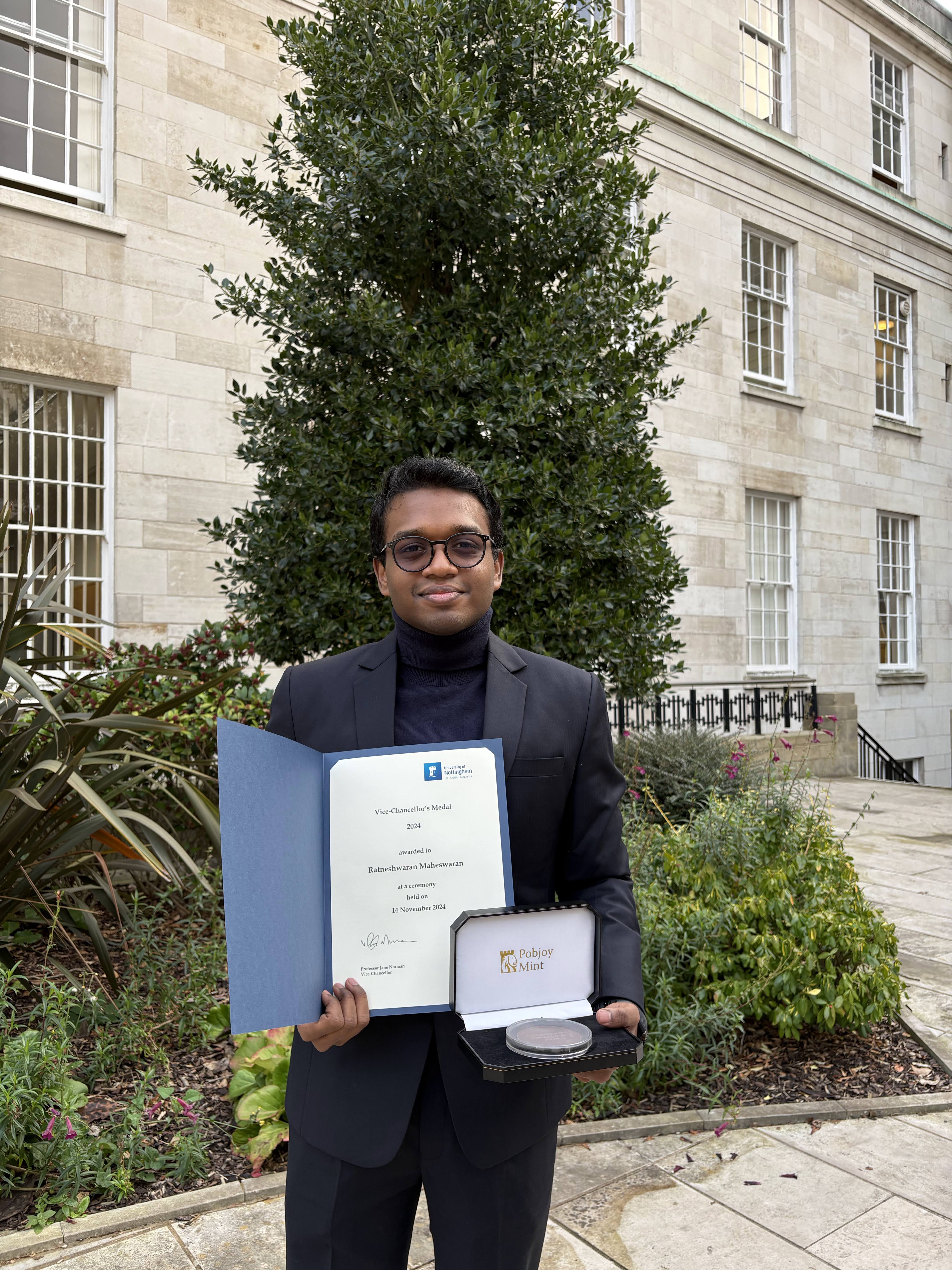 Ratneshwaran Maheswaran holding the Vice-Chancellor's Medal certificate and medal at the University of Nottingham